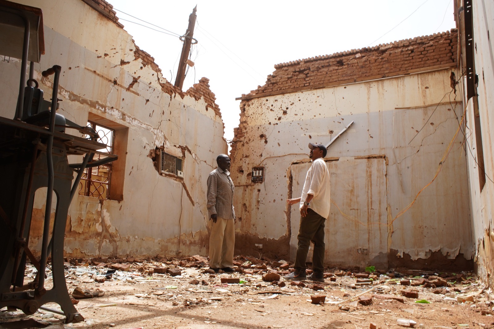 Surveying a home damaged by the war in Sudan